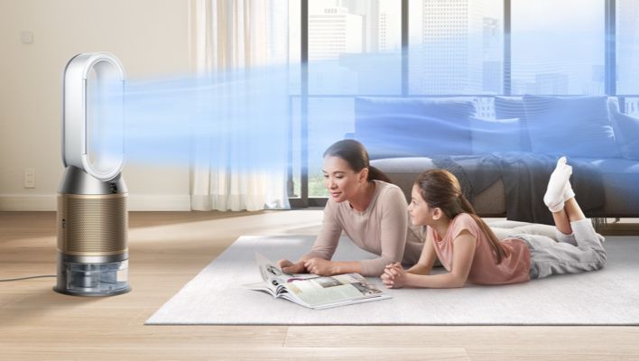 M&egrave;re et fille allong&eacute;es sur une moquette avec un humidificateur purificateur Dyson en train de les ventiler