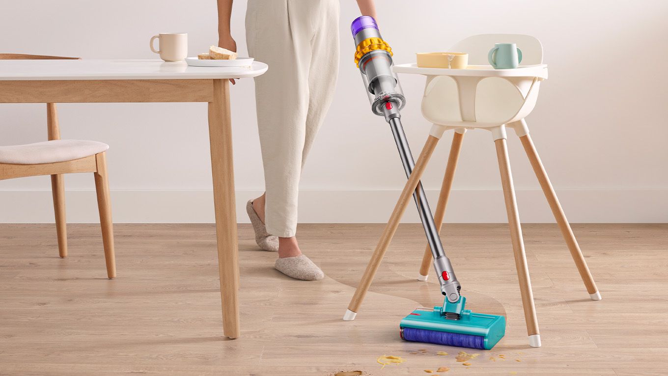 La brosse lavante en train de s&rsquo;orienter entre les pieds d&rsquo;une chaise haute.