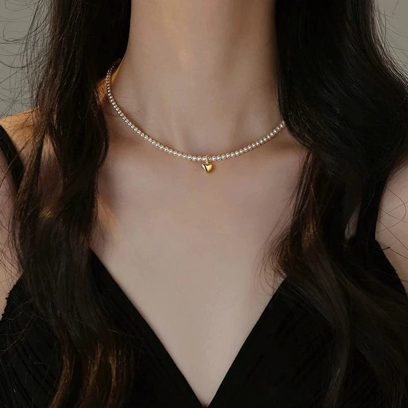 Collier ras-du-cou en perle avec une petite médaille centrale